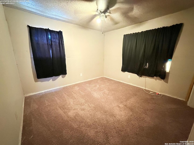 carpeted spare room featuring a textured ceiling and a ceiling fan