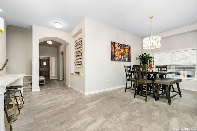 13818 Cessna, San Antonio, TX 78245 - dining area featuring arched walkways, baseboards, and a notable chandelier
