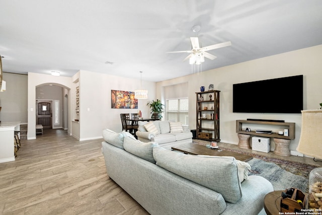 13818 Cessna, San Antonio, TX 78245 - living room featuring light wood-style floors, arched walkways, ceiling fan, and baseboards