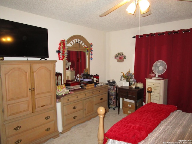 bedroom featuring a ceiling fan, light colored carpet, and a textured ceiling