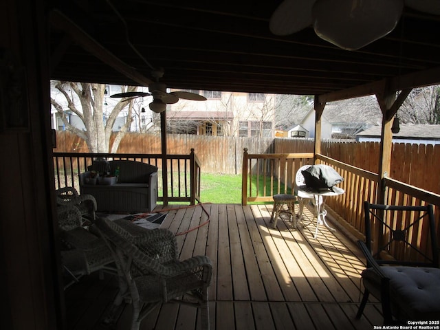 deck with a ceiling fan and a fenced backyard