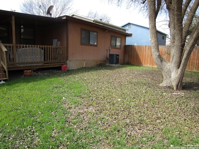 rear view of house featuring a deck, a yard, cooling unit, and fence