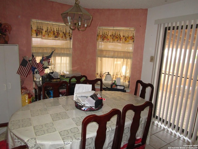 dining space featuring plenty of natural light, tile patterned flooring, and a notable chandelier