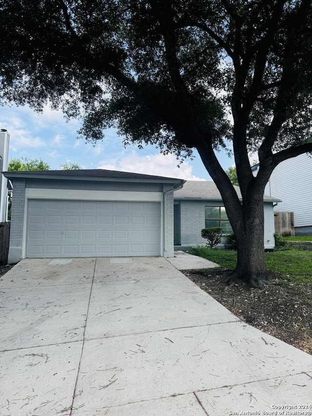 ranch-style house featuring brick siding, driveway, and an attached garage