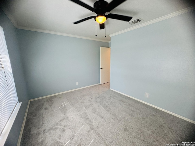 empty room featuring visible vents, ornamental molding, a ceiling fan, light carpet, and baseboards