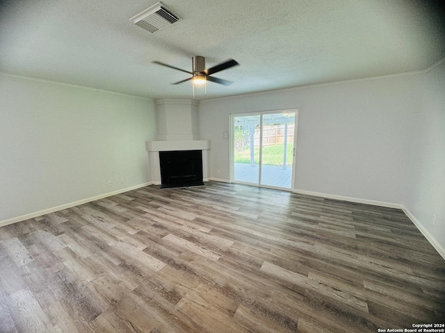 unfurnished living room featuring visible vents, ornamental molding, a large fireplace, a textured ceiling, and wood finished floors