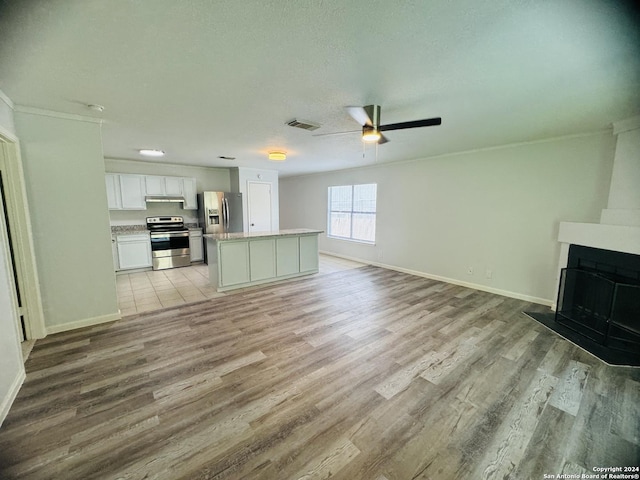 unfurnished living room with baseboards, a fireplace with flush hearth, light wood-style flooring, and a ceiling fan