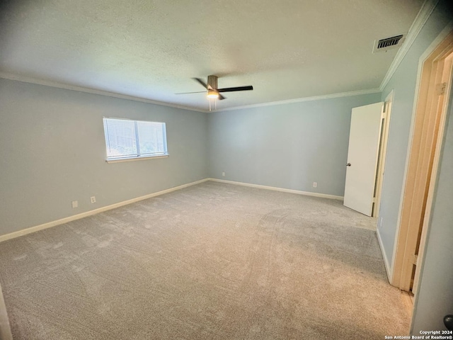 unfurnished bedroom with baseboards, visible vents, light colored carpet, a textured ceiling, and crown molding