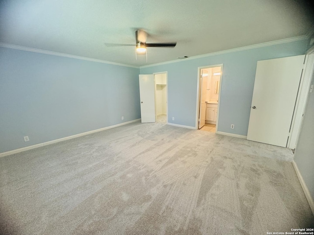 unfurnished bedroom with baseboards, a spacious closet, ornamental molding, and visible vents