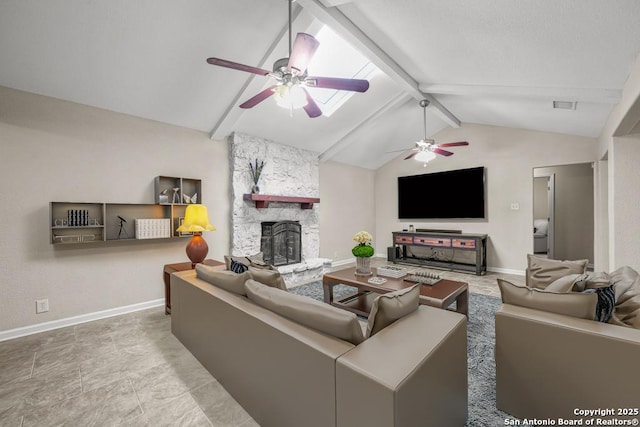 living room with vaulted ceiling with beams, a stone fireplace, baseboards, and ceiling fan