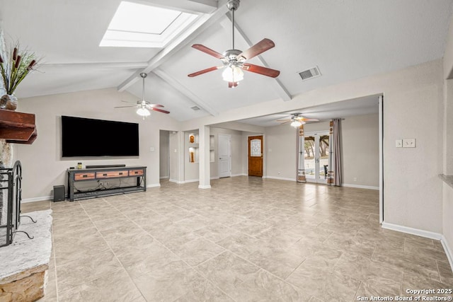 living area with lofted ceiling with skylight, visible vents, a fireplace with raised hearth, and baseboards