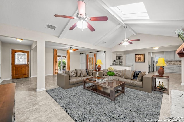 living area with vaulted ceiling with skylight, a barn door, visible vents, and baseboards