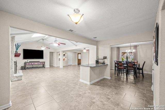 kitchen with visible vents, lofted ceiling with beams, open floor plan, a textured ceiling, and dark stone countertops