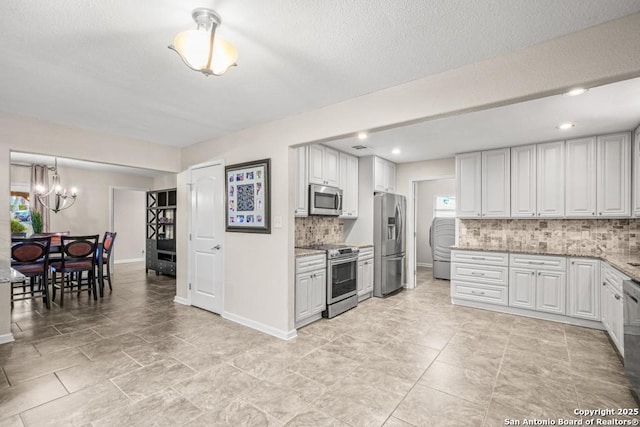 kitchen with tasteful backsplash, appliances with stainless steel finishes, white cabinets, and a healthy amount of sunlight