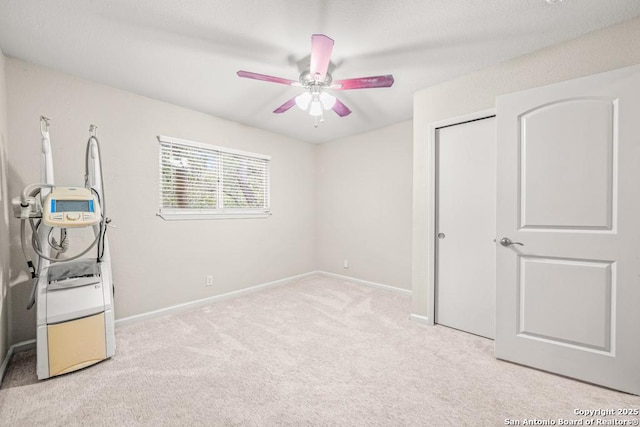 unfurnished bedroom featuring baseboards, a closet, a ceiling fan, and light colored carpet