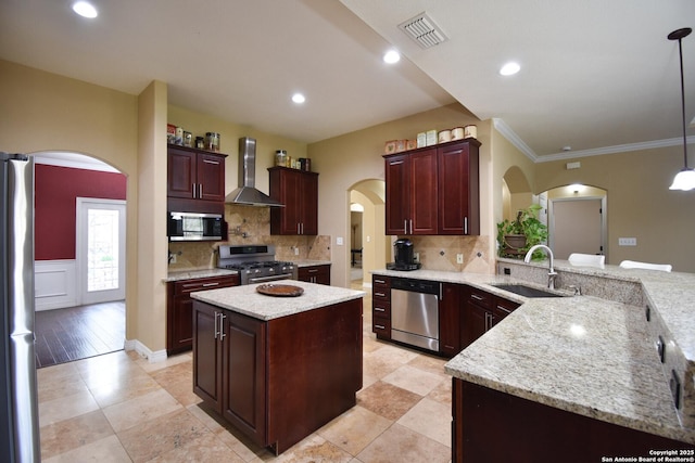 kitchen with decorative light fixtures, visible vents, appliances with stainless steel finishes, a sink, and a kitchen island