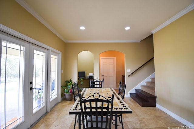 dining area featuring a healthy amount of sunlight, baseboards, arched walkways, and crown molding