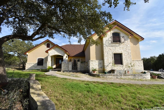 view of front of house with stone siding, a front yard, and stucco siding