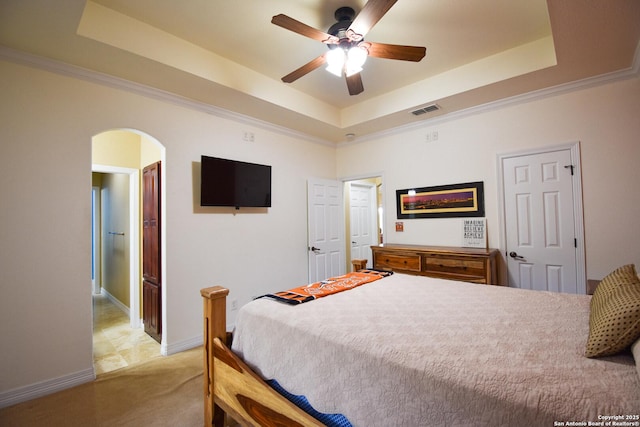 bedroom with visible vents, arched walkways, and a raised ceiling