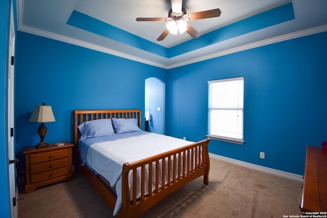 carpeted bedroom with arched walkways, ornamental molding, a raised ceiling, and baseboards