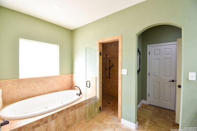 full bath with a tub with jets, a stall shower, and tile patterned floors