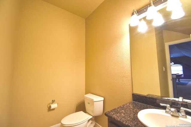 bathroom with vanity, toilet, and baseboards