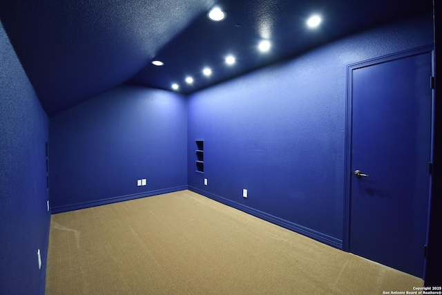 interior space with baseboards, vaulted ceiling, a textured ceiling, and recessed lighting