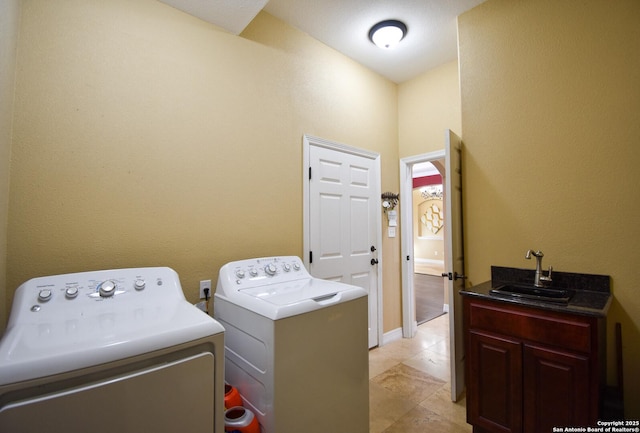 laundry area featuring washer and clothes dryer, a sink, and cabinet space