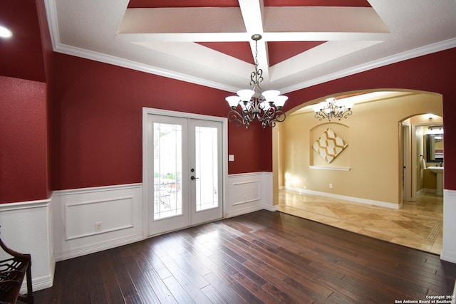 interior space featuring wainscoting, ornamental molding, dark wood-style flooring, a tray ceiling, and french doors