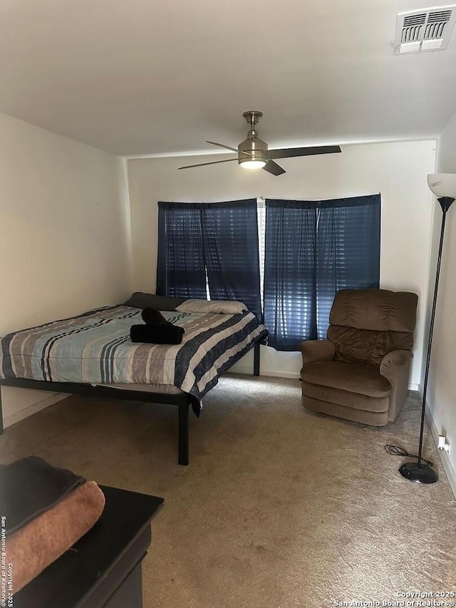 carpeted bedroom featuring ceiling fan and visible vents