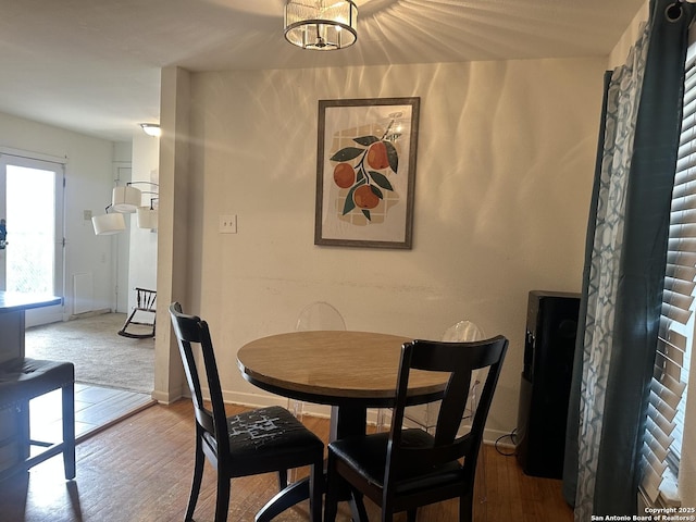 dining room featuring a notable chandelier, wood finished floors, and baseboards