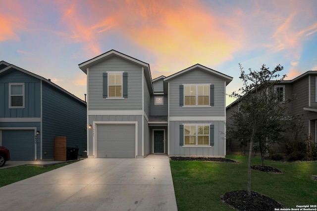 traditional home with driveway, board and batten siding, an attached garage, and a lawn