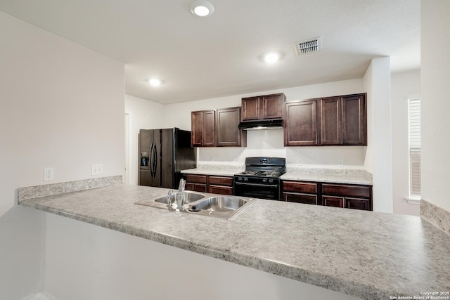 kitchen featuring a peninsula, black appliances, and a sink