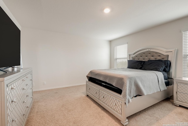 bedroom featuring baseboards and light colored carpet