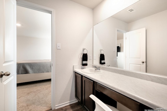 bathroom featuring vanity, connected bathroom, visible vents, and baseboards