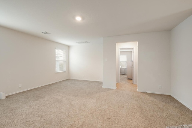 unfurnished room featuring visible vents, light carpet, and baseboards