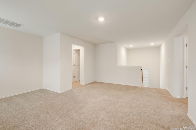 unfurnished room with baseboards, light colored carpet, visible vents, and recessed lighting