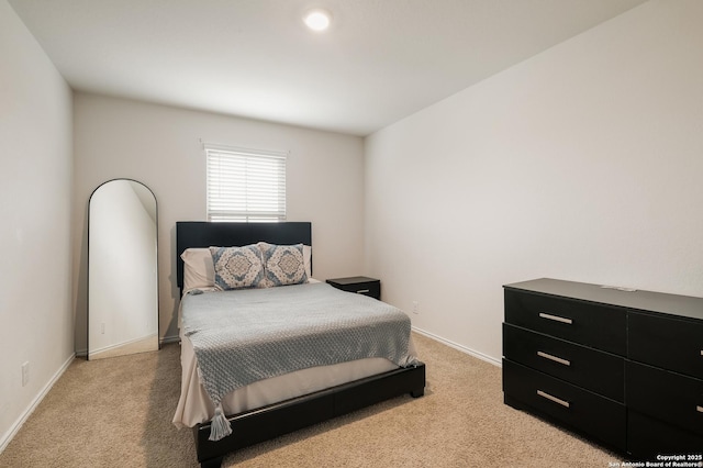 bedroom featuring light carpet and baseboards