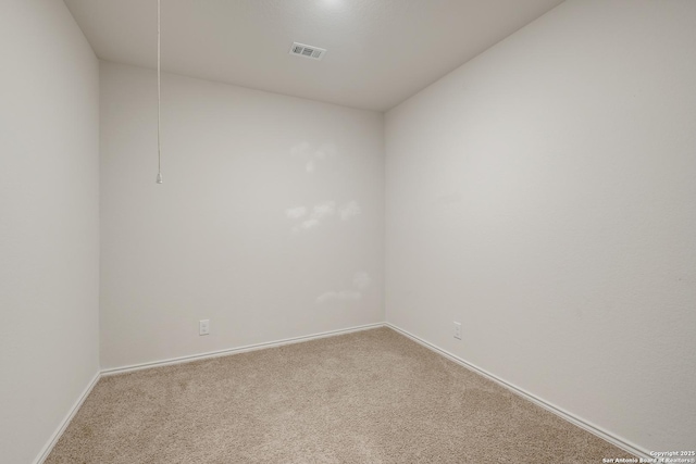 carpeted spare room featuring baseboards and visible vents