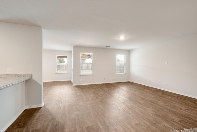 empty room with dark wood-style floors and baseboards