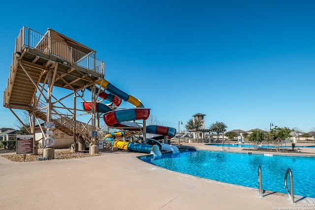 pool featuring a patio area and a water slide