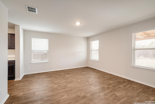 interior space with baseboards, visible vents, and wood finished floors