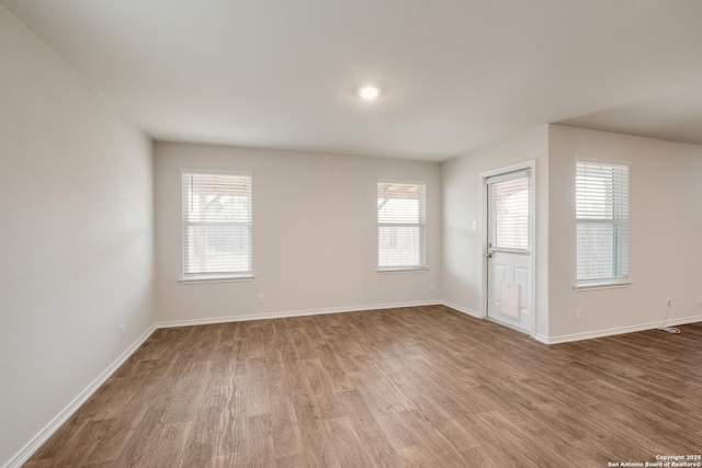 empty room featuring baseboards and wood finished floors