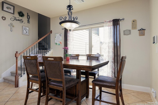 dining room with light tile patterned floors, visible vents, stairs, and baseboards