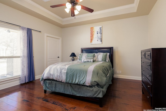 bedroom featuring crown molding, a raised ceiling, baseboards, and hardwood / wood-style flooring