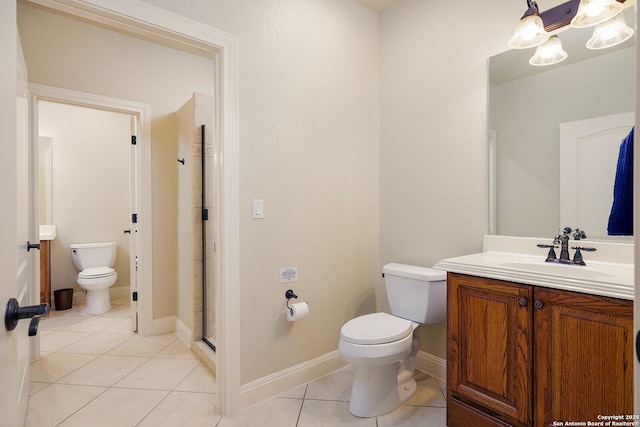 full bath with vanity, baseboards, tile patterned flooring, a shower stall, and toilet