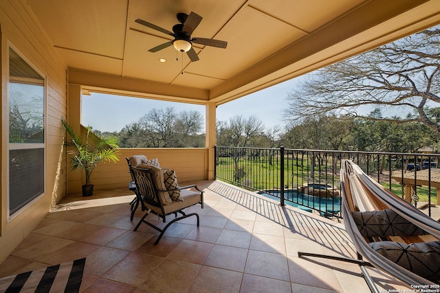 view of patio with a fenced in pool, a ceiling fan, and a balcony