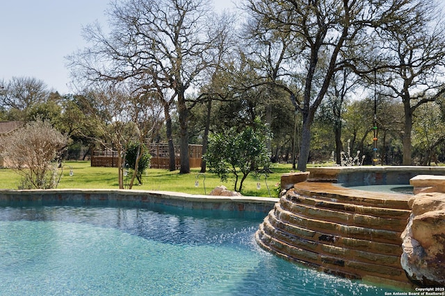 outdoor pool featuring a jacuzzi and a yard