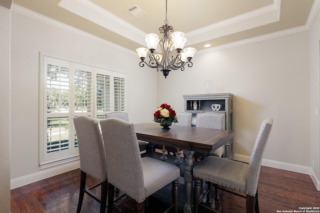 dining area with visible vents, a raised ceiling, baseboards, and wood finished floors