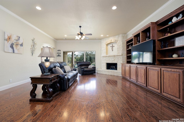 living room with a ceiling fan, baseboards, a fireplace, dark wood-style flooring, and crown molding